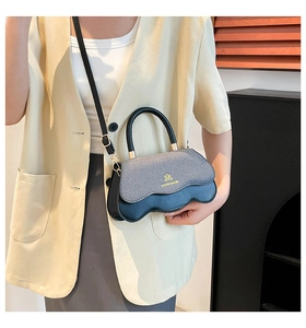 Detail of gray fabric and black leather contrast with elegant wavy bottom edge design