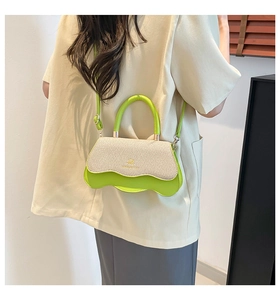 Detail view of mini crossbody bag with wavy neon green base and beige straw flap on model