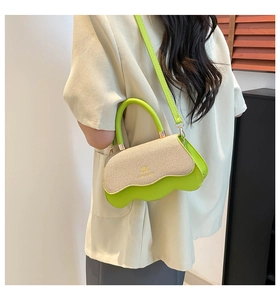 Detail of neon green leather and straw crossbody bag with wavy edges and gold logo