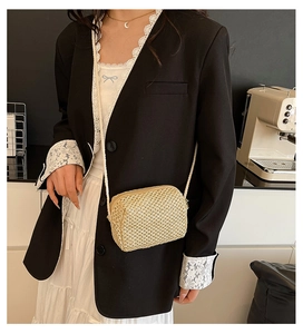 Detail of beige handwoven mini crossbody bag with zipper and slim rope strap on model