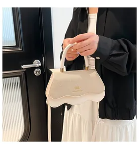 Detail of elegant wavy flap handbag with gold monogram hardware and striped fabric texture