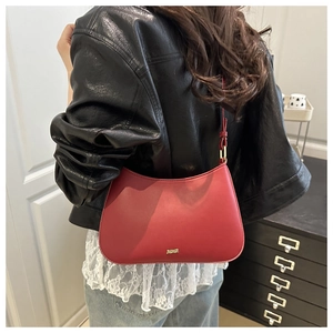 Détail du sac rouge foncé avec le logo doré JM.MARR sur un cuir à texture mate