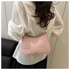 Détail du sac demi-lune rose avec logo JW PEI doré sur similicuir lisse et élégant