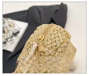 Detail shot of smooth gold-tone metal zipper on a handcrafted woven straw crossbody bag