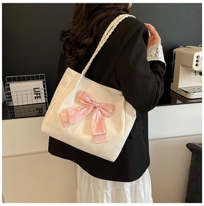 White shoulder tote bag with pink silk bow detail and braided leather handles