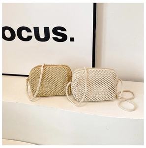 Detailed view of hand-woven mini crossbody straw bags in khaki and beige tones