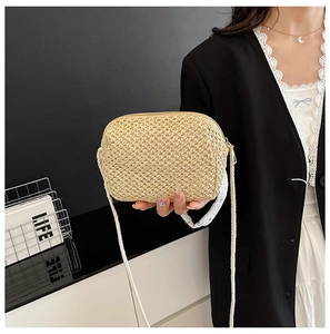 Detail of hand-woven straw crossbody bag with beige texture and zipper closure