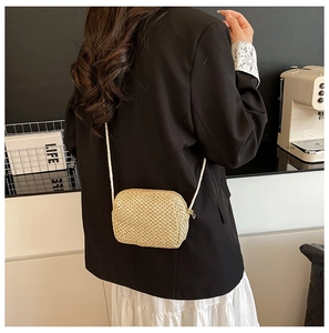 Detailed back view of a person wearing the handmade woven crossbody bag in beige