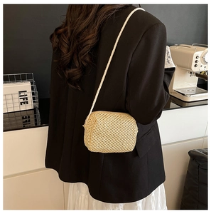 Detailed side view of handmade straw crossbody mini bag with natural woven texture