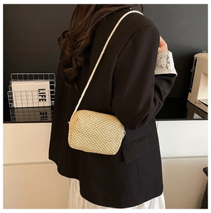 Back view of a model wearing a hand-woven rectangular straw crossbody bag for summer