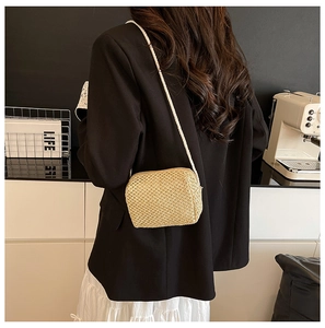 Detail of hand-woven straw crossbody bag texture with crossbody back-view on model