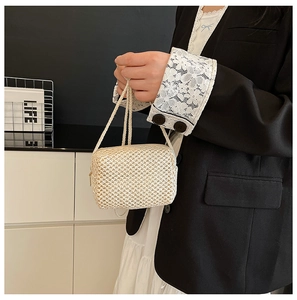 Detail showing the fine cross-weave texture and side metal zipper of the cream woven bag