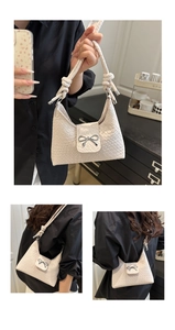 Close-up of woven bucket bag with silver bow buckle and textured knit surface