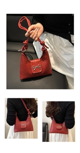 Detail view of a red woven bucket bag with silver metal bow and knotted strap design