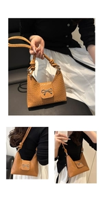 Detail of brown woven faux leather shoulder bag featuring a silver metal bow buckle accent