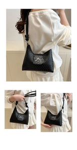 Detail of woven black shoulder bag with silver bow buckle and knotted strap accents