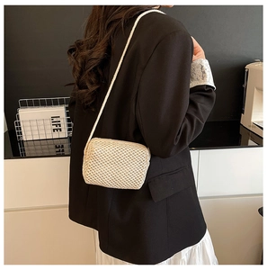 Detail of off-white hand-woven mini crossbody bag featuring a fine texture and thin strap