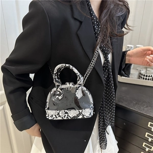 Mini snakeskin pattern shell bag with silver chain strap shown on black blazer model
