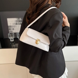 White faux crocodile pattern underarm bag with gold hardware worn by model