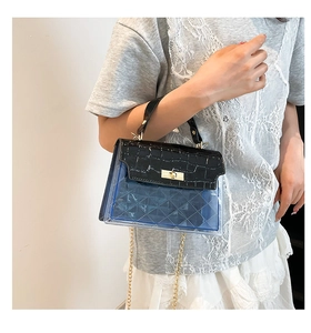 Detail of blue plaid jelly bag featuring black croc-textured flap and golden twist lock