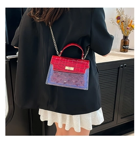 Detail of red crocodile texture flap and blue quilted PVC on a mini crossbody bag