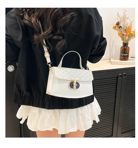 Detail of white chain crossbody bag with golden twist lock and letter print flap