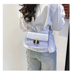 Detail of lilac small square bag with golden T-buckle and letter embossing on crossbody strap
