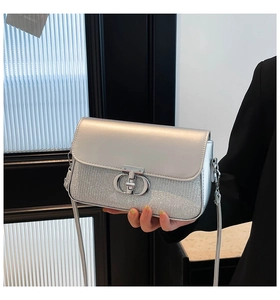 Détail du sac à bandoulière argenté avec rabat miroir et texture scintillante