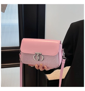 Détail du sac à bandoulière rose avec fermoir CD et texture scintillante par mannequin