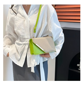 Detail view of stylish lime green and beige woven crossbody bag with chain strap