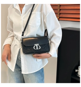Détail du sac bandoulière noir avec strass brillants et boucle en métal argenté élégante