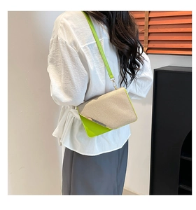 Détail du sac bandoulière en texture tissée beige, cuir vert néon et bordure dorée