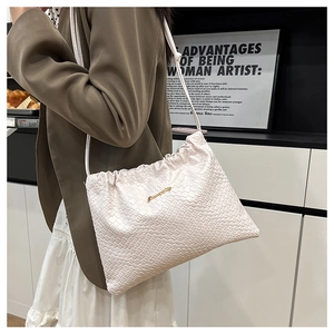 Vue détaillée du sac bourse tressé blanc montrant la texture en cuir à damier