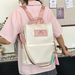 Women's cream nylon backpack with pink straps and decorative tassel for summer