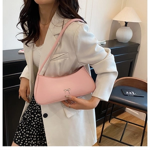 Chic pink shoulder bag styled with white blazer and silver metal bow detail