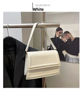 Detalle de un bolso de hombro en cuero blanco con solapa y correa ajustable
