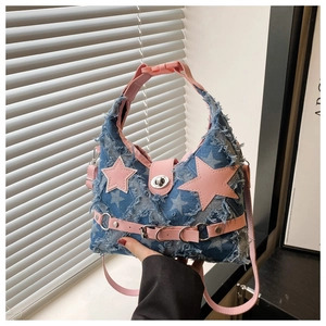 Dettaglio della stella in pelle rosa e rivetti sulla borsa a tracolla in denim a stelle
