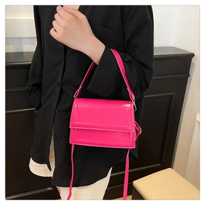 Detalle del bolso rosa neón en cuero PU brillante con correa ajustable para el hombro