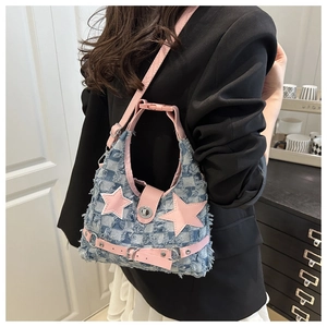 Dettaglio borsa a tracolla in denim con stella rosa e trama a frange consumate