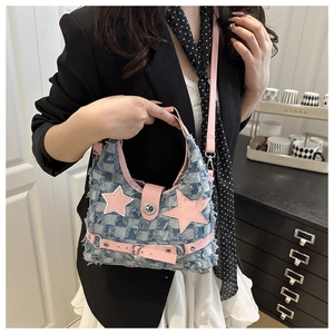 Dettaglio della borsa tote in denim blu con toppa a stella rosa e chiusura argentata