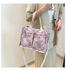 Detail of lavender tote bag with gray leaf print and adjustable white straps on model