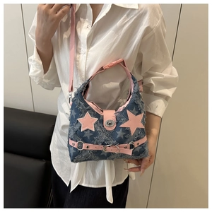 Dettaglio borsa a tracolla in denim blu con stelle rosa e rifiniture a frange