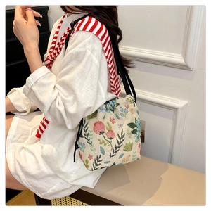 Detailed view of large capacity floral jacquard drawstring bucket bag with black straps