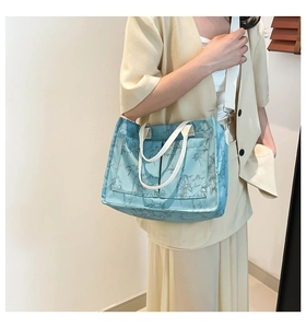 Light blue canvas tote bag featuring grey bamboo patterns shown in side view on model