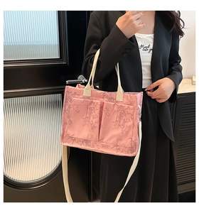 Detail of pink tote bag with leaf pattern, double handles and adjustable strap