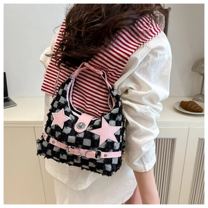Dettaglio borsa a scacchi con stella rosa e finiture con bordi sfrangiati alla moda