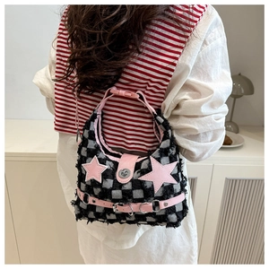 Dettaglio della borsa sottobraccio in lana a scacchi con stelle rosa e fibbie in pelle