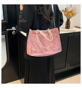 Detailed back view of a pink tote bag with grey bamboo leaf patterns on a model