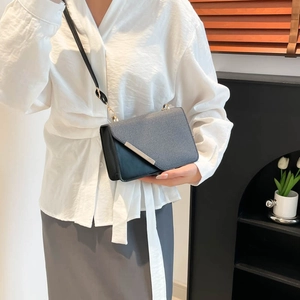 Petit sac à bandoulière bicolore avec bordure dorée et bandoulière chaîne élégant