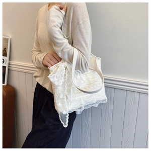 Detailed close-up of white floral lace texture on a large tote bag with elegant scalloped edges